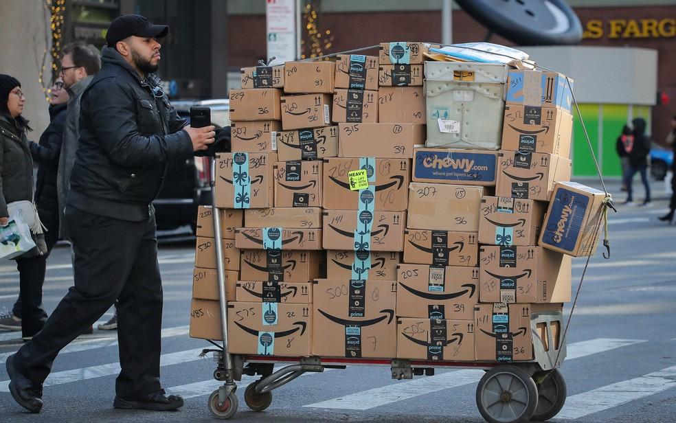 Homem transporta caixas da Amazon nas ruas de Nova York — Foto: Brendan McDermid/Reuters